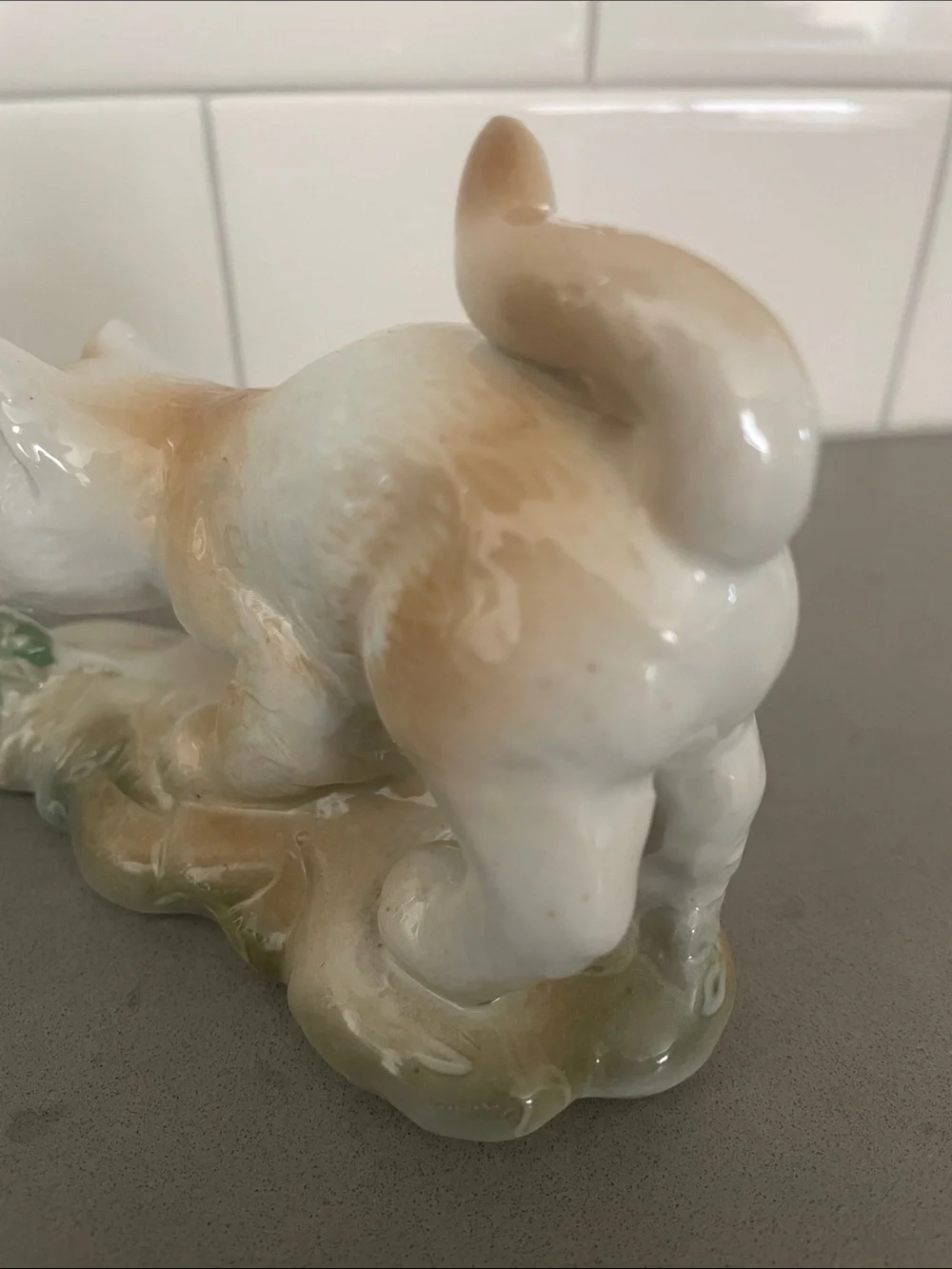 Vintage porcelain cat figurine playing with a butterfly.